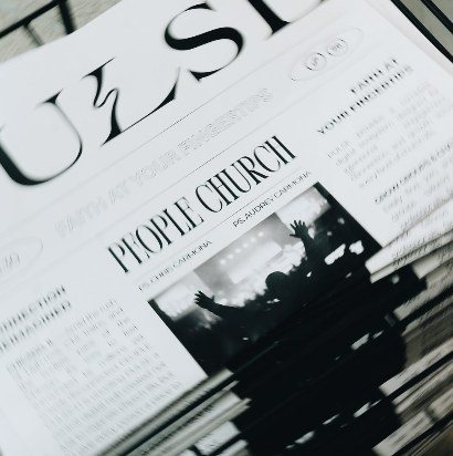 A church bulletin with a black-and-white photo of hands raised in worship